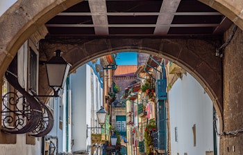 Historisk stenbue med udsigt over farverig middelalderlig gade i Portugal med traditionelle bygninger