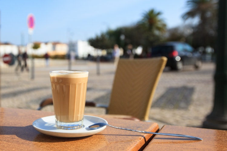 Traditionel portugisisk galao kaffe serveret på udendørs café terrasse i Tavira Algarve
