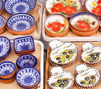 Farverige håndlavede portugisiske keramiktallerkener og skåle med traditionelle mønstre fra marked i Cascais