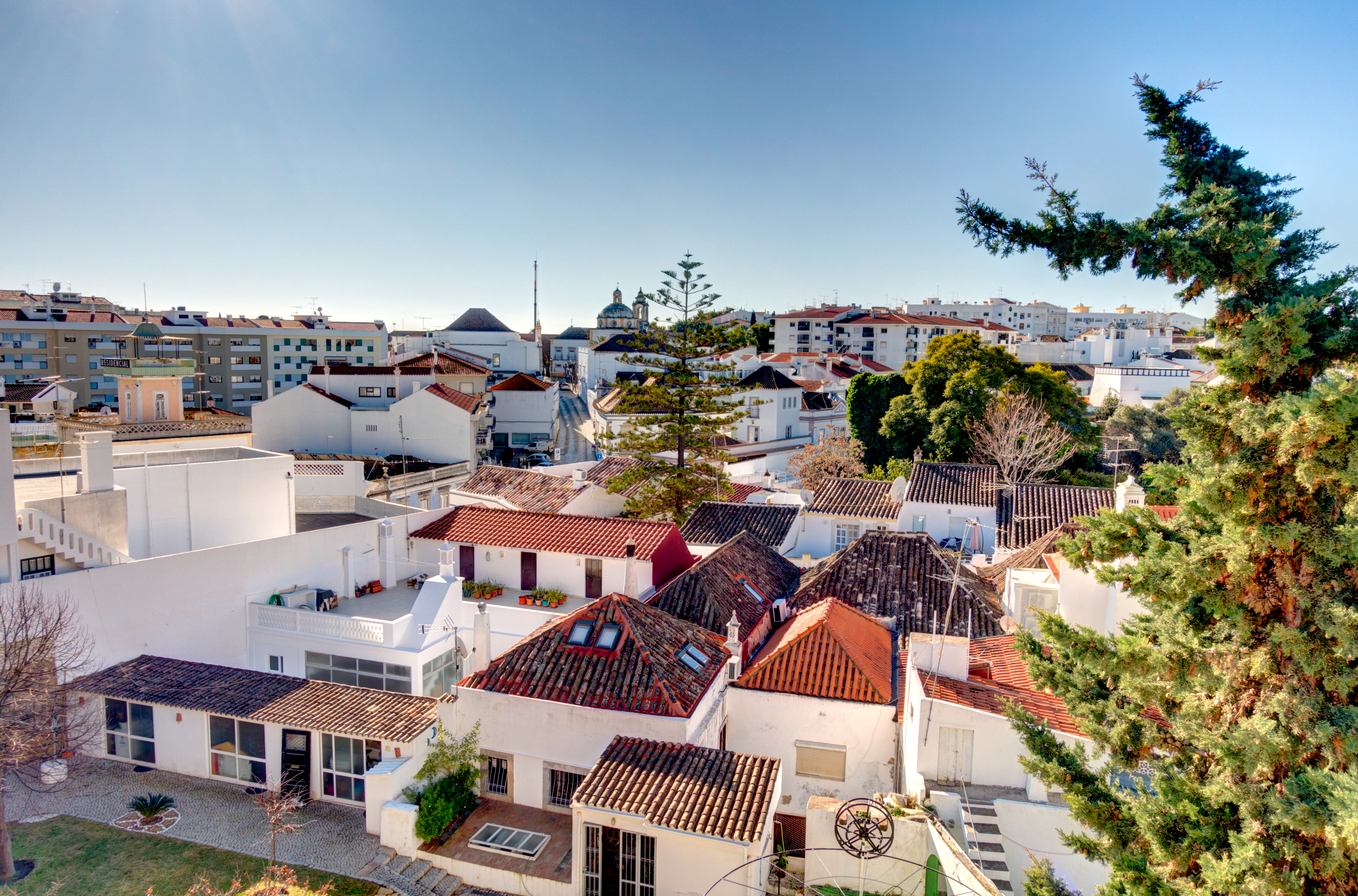 Panoramaudsigt over traditionelle hvide huse med røde tegltagsten i charmerende portugisisk kystby