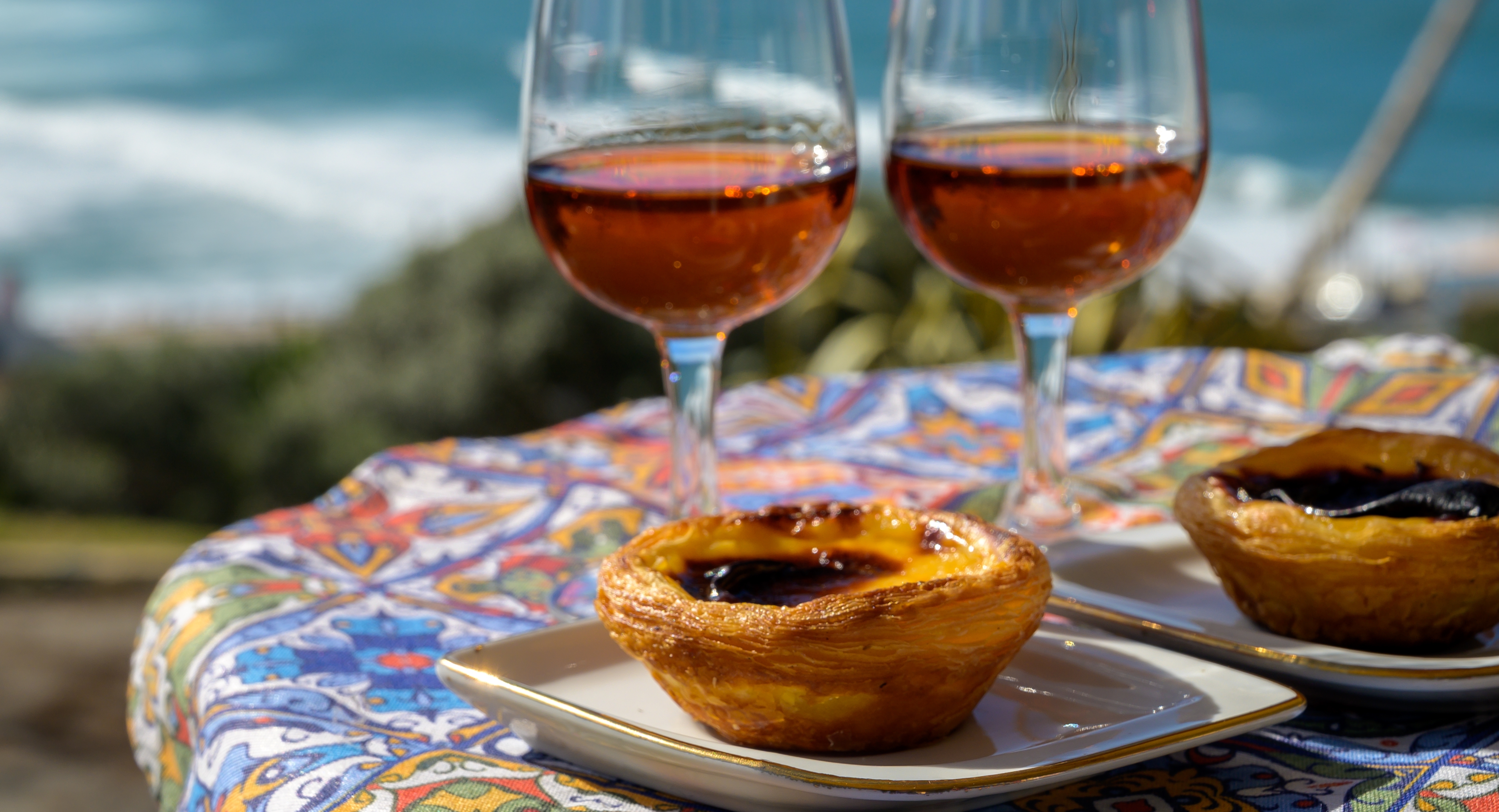 Traditionelle portugisiske Pastel de Nata og portvin nydes med udsigt over Atlanterhavet nær Sintra i Lissabon-området