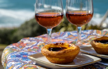 Traditionelle portugisiske Pastel de Nata og portvin nydes med udsigt over Atlanterhavet nær Sintra i Lissabon-området