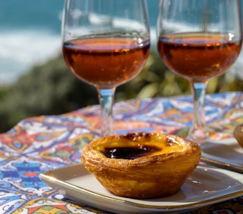 Traditionelle portugisiske Pastel de Nata og portvin nydes med udsigt over Atlanterhavet nær Sintra i Lissabon-området