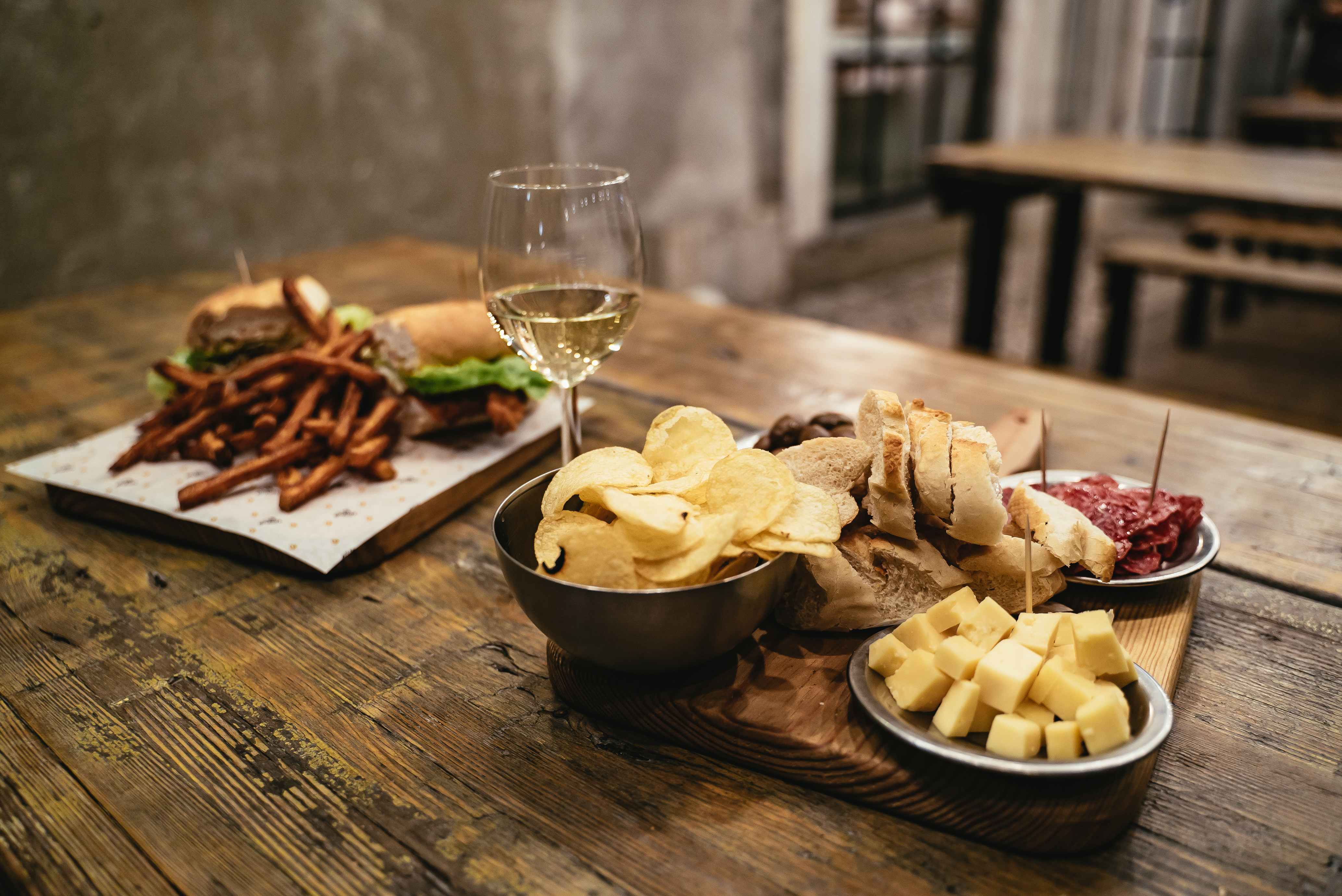 Traditionel portugisisk tapas med salami, ost og oliven på rustik restaurant i LX Factory, Lissabon