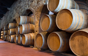 Rækker af traditionelle portvinsfade i en historisk vinkælder i Porto, Portugal