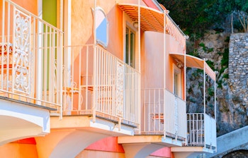 Charmerende italiensk altan med farverige blomsterkrukker på en traditionel bygning i Positano ved den maleriske Amalfikyst