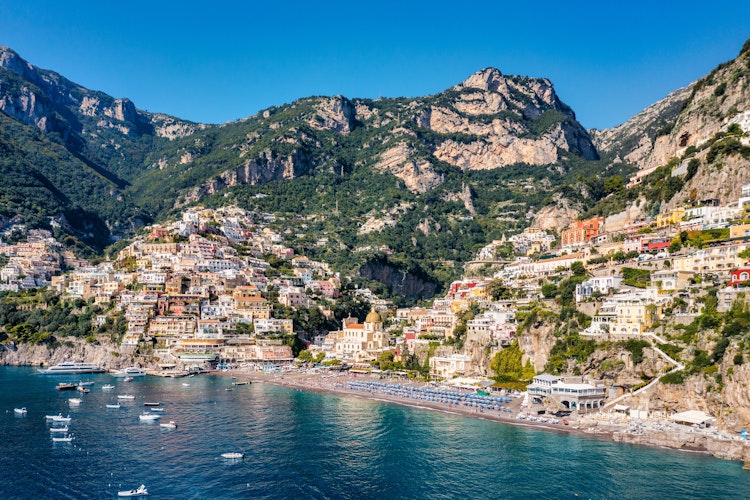 Betagende panoramaudsigt over Positano ved Amalfikysten i Campania, Italien, med farverige bygninger der kaskader ned til en smuk sandstrand og det azurblå Middelhav