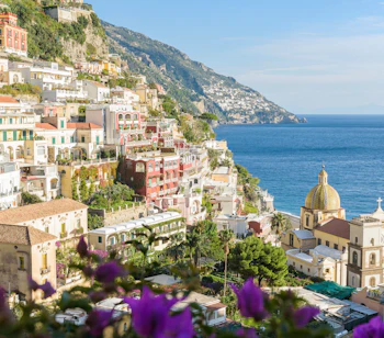 Smuk kystby Positano paa Amalfikysten med farverige huse og kirke ved Middelhavet