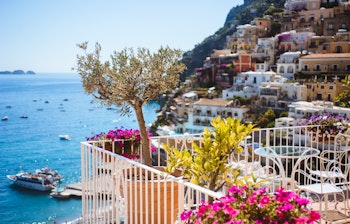 Malerisk udsigt over Positano ved Amalfi-kysten med farverige huse der skråner ned mod det azurblå Middelhav i solskinsvejr