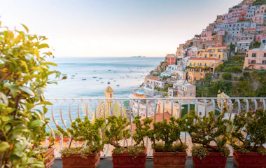 Smuk solnedgang over Positano på Amalfi-kysten med farverige huse og terrasser med havudsigt