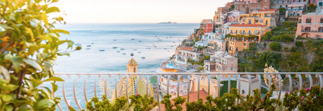 Smuk solnedgang over Positano på Amalfi-kysten med farverige huse og terrasser med havudsigt