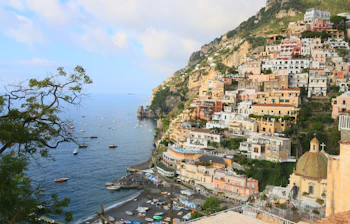 Malerisk udsigt over Positanos farverige bygninger, strand og det azurblå hav på Amalfi-kysten i Italien