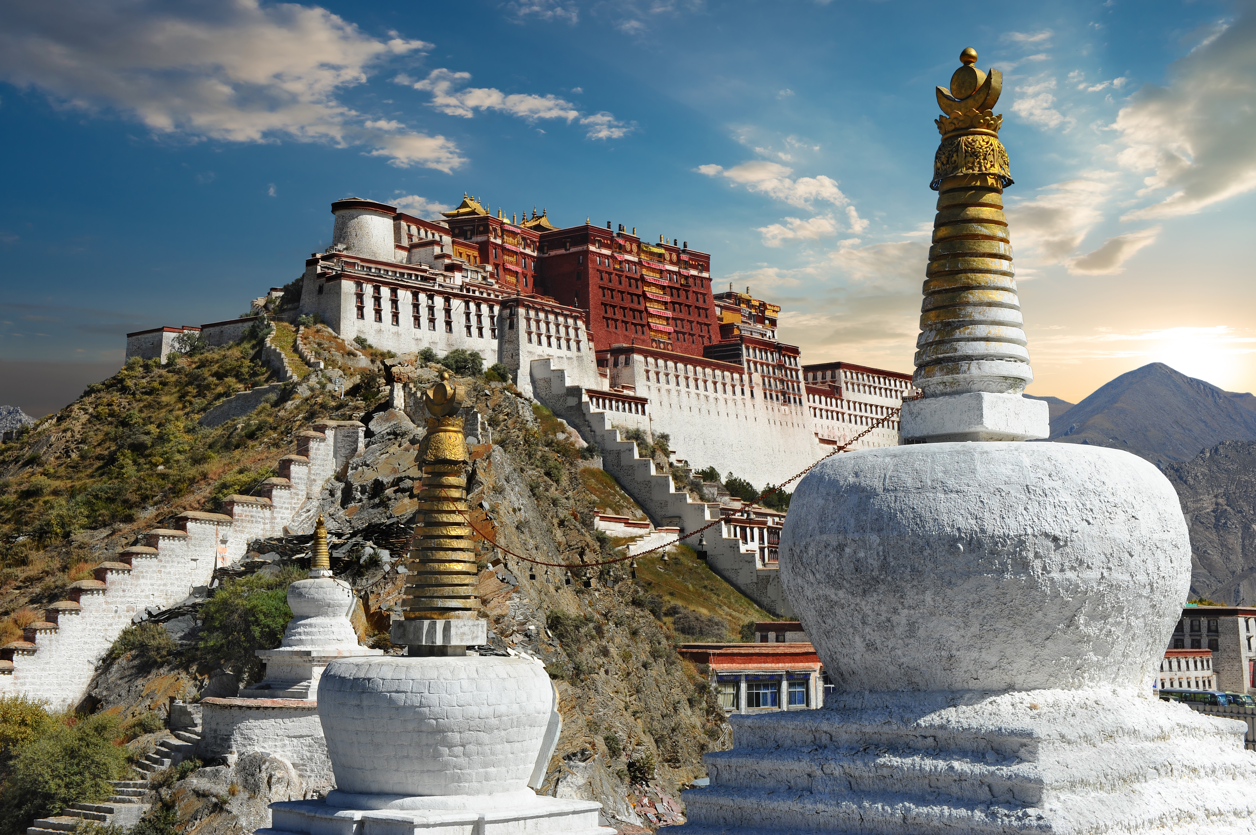 Potala Palads og hvide buddhistiske stupaer i Lhasa Tibet med bjerglandskab