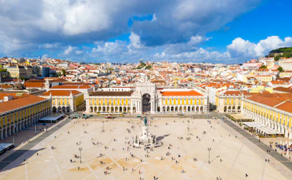 Luftfoto af Praça do Comércio i Lissabon Portugal med gule bygninger og triumfbue
