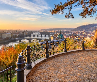 Prahas smukke efterårsudsigt fra Petrin Bakke med Vltava-floden og historiske broer i solnedgang