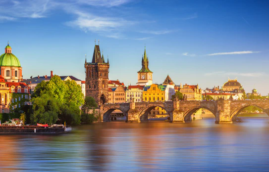 Karlsbroen i Prag med historiske kirker og farverige bygninger ved Vltava floden