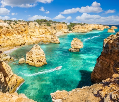 Betagende udsigt over Praia da Marinha stranden med gyldne klipper og turkisblåt vand i Algarve, Portugal