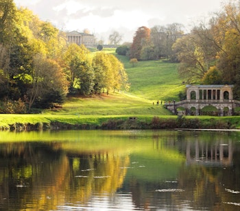 Historisk stenbro omgivet af farverige efterårstræer i Prior Park Landscape Garden nær Bath i England