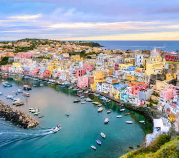 Farverige huse og marina på Procida øen, Italien med både i turkisblåt middelhav