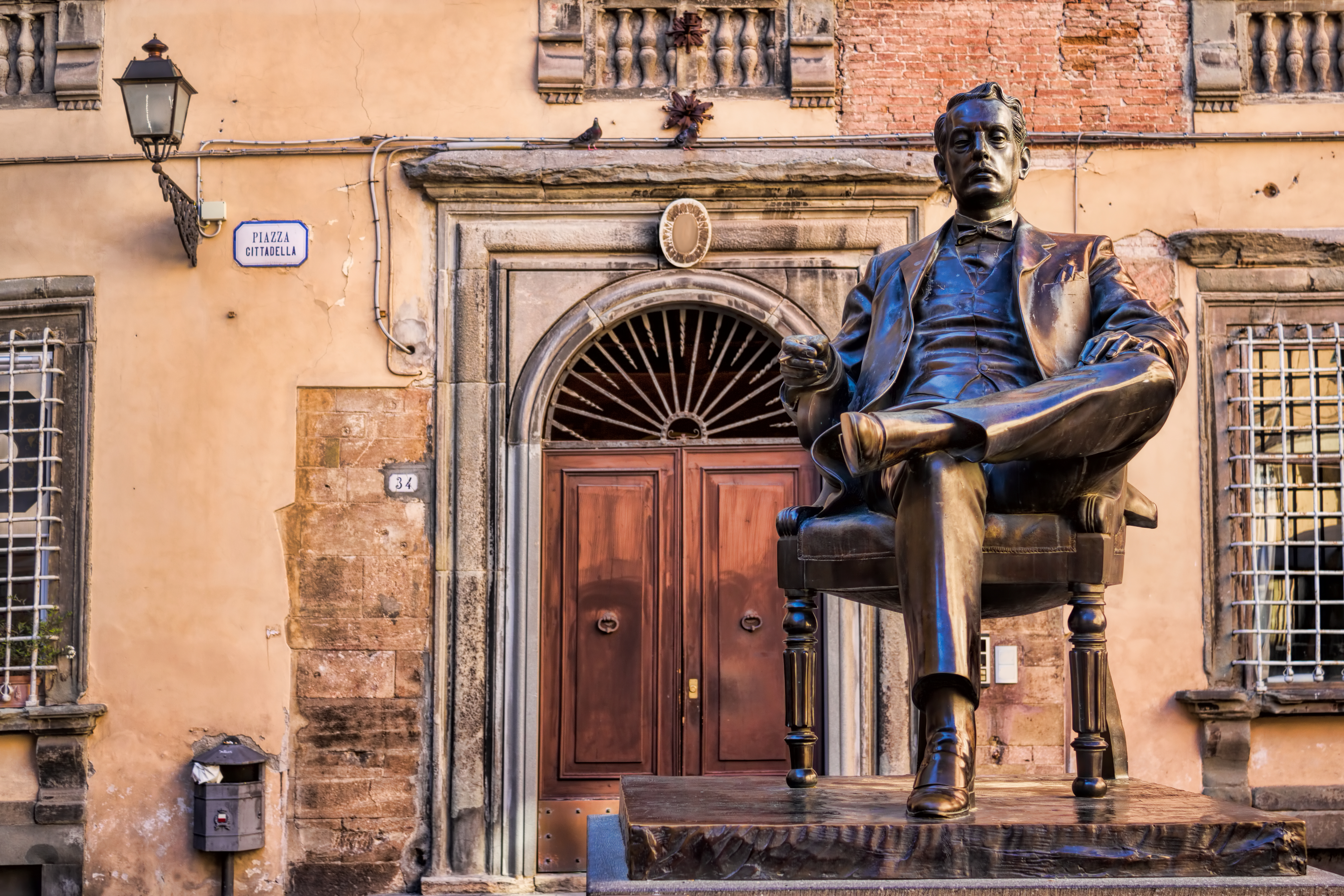 Monumentet for komponisten Giacomo Puccini på Piazza Cittadella i den historiske by Lucca, Toscana, hvor den berømte operakomponist sidder i en bronzestol