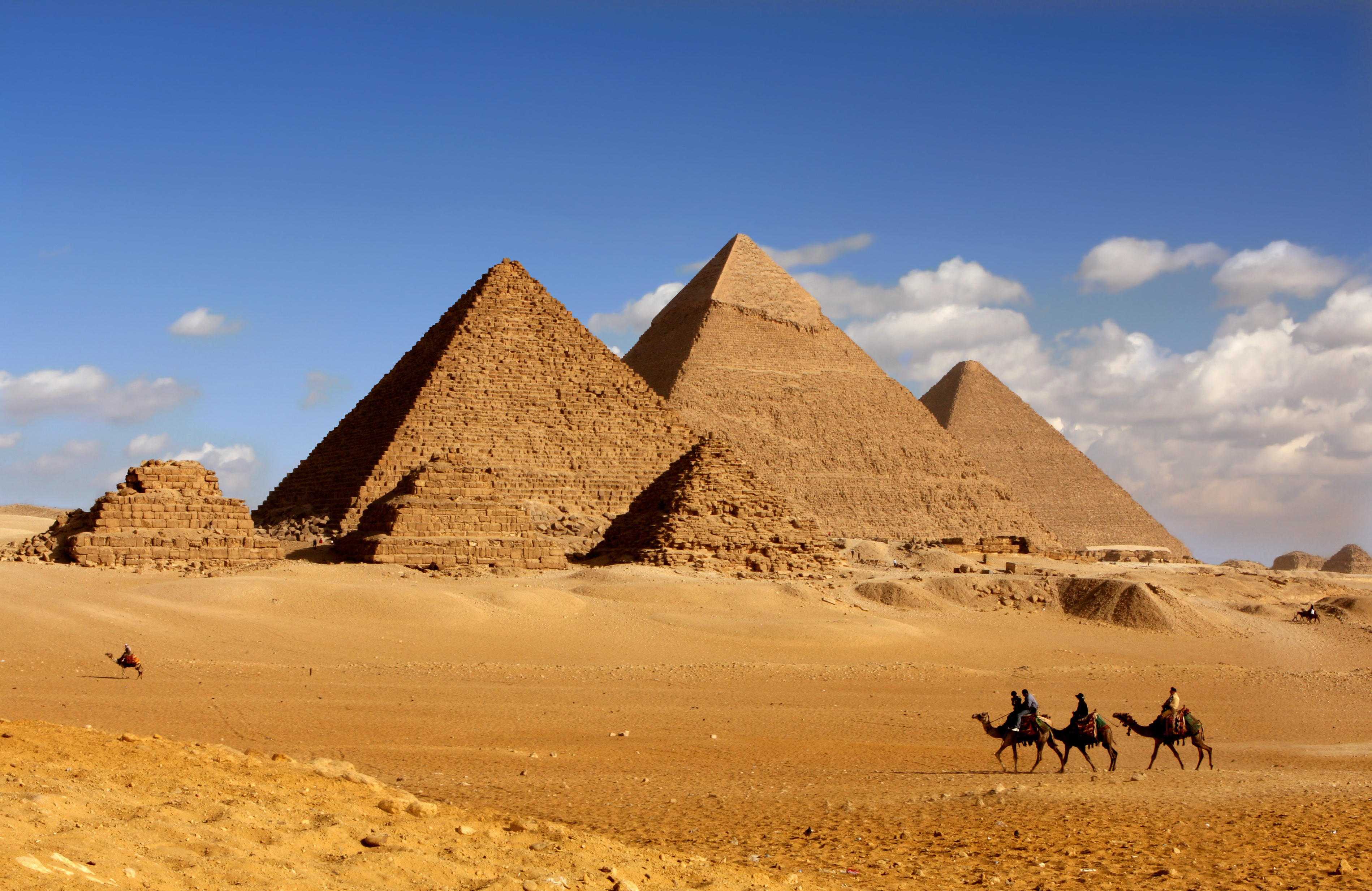 Panoramaudsigt over de store pyramider i Giza nær Cairo i Egypten med en kamelkaravan i ørkenen under en blå himmel
