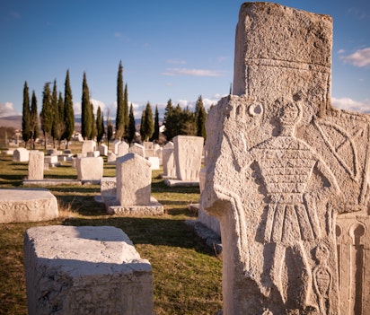 Historiske stećak-gravsten med dekorative udskæringer fra middelalderen i Radimlja nekropolis, et fascinerende kulturarvssted i Bosnien