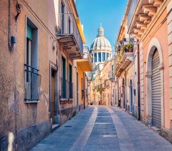 Smuk brolagt gade i historiske Ragusa på Sicilien med barok katedral