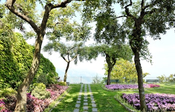 Smuk panoramaudsigt fra Belvedere Principessa di Piemonte haverne i Ravello på Amalfikysten. Velholdte grønne plæner, farverige blomsterbede og stensatte stier med betagende udsigt over Middelhavet.
