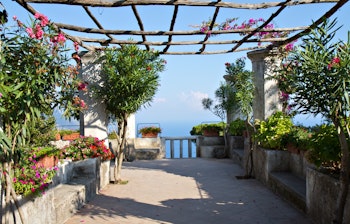 Idyllisk mediterrænsk have med pergola og havudsigt ved en villa i Ravello på Amalfikysten i Italien