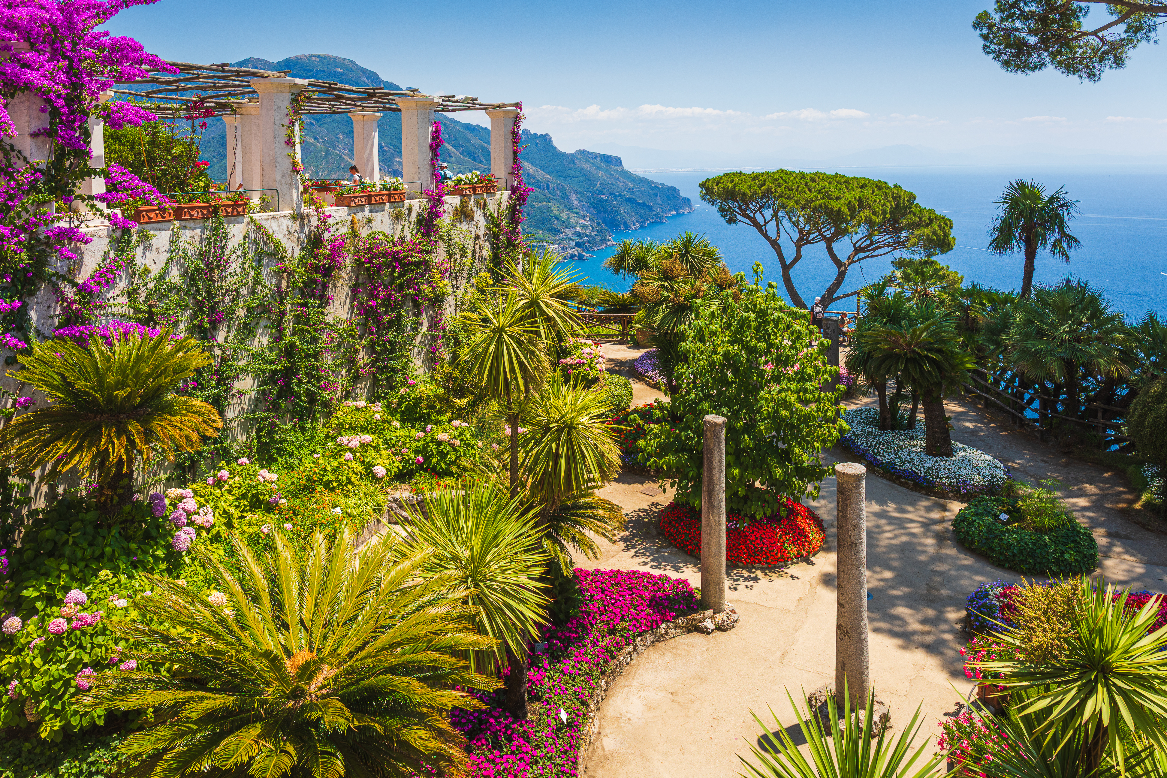 Smuk terrasse-have ved Villa Rufolo i Ravello med farverige bougainvillea-blomster og storslået udsigt over Amalfikysten i Campania, Italien