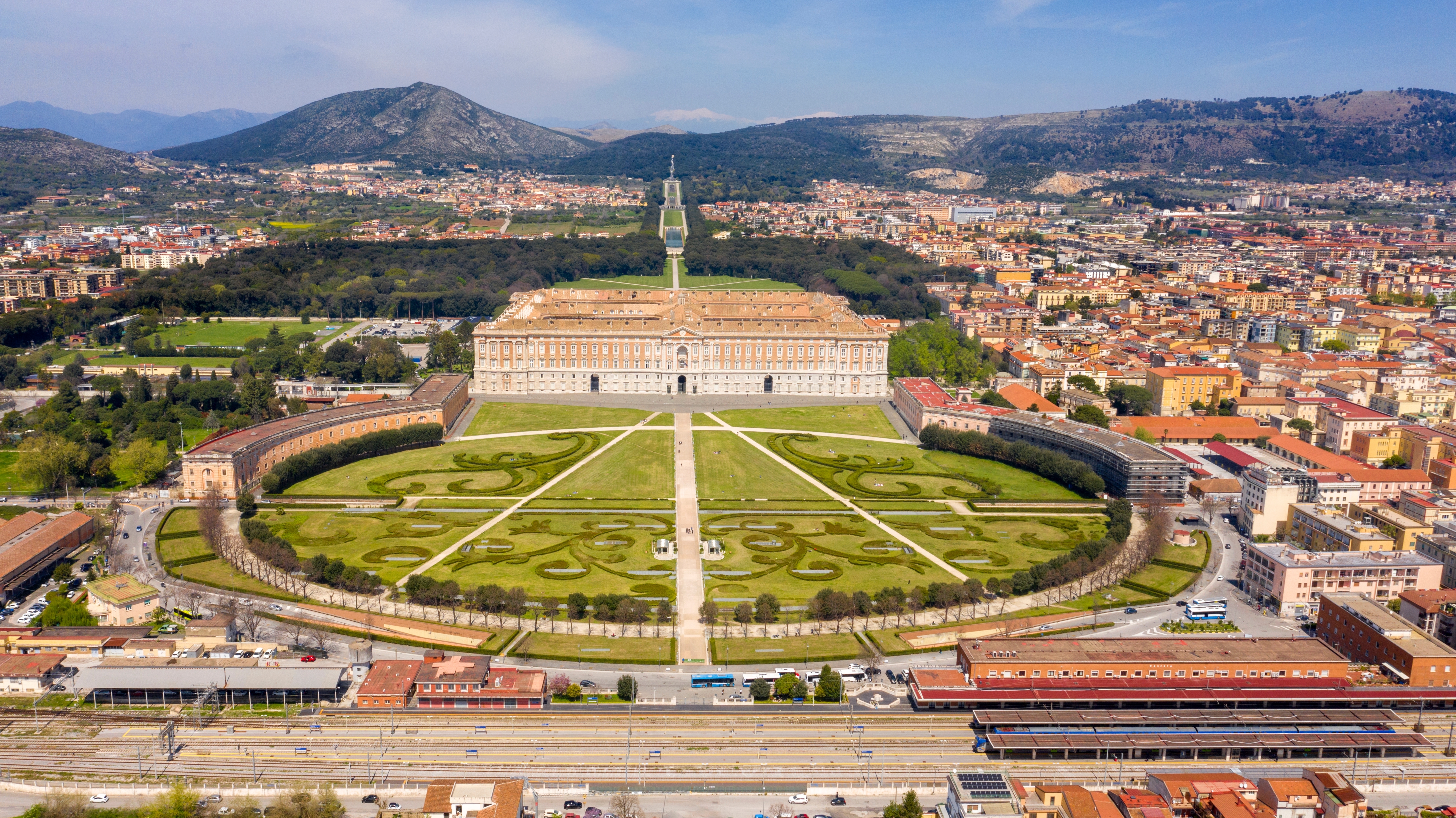 Luftfoto af Reggia di Caserta – det kongelige palads i Caserta med smukke barokhaver og udsigt over byen nær Napoli, Italien