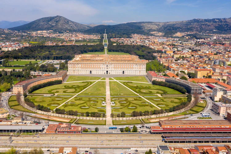 Luftfoto af Reggia di Caserta – det kongelige palads i Caserta med smukke barokhaver og udsigt over byen nær Napoli, Italien