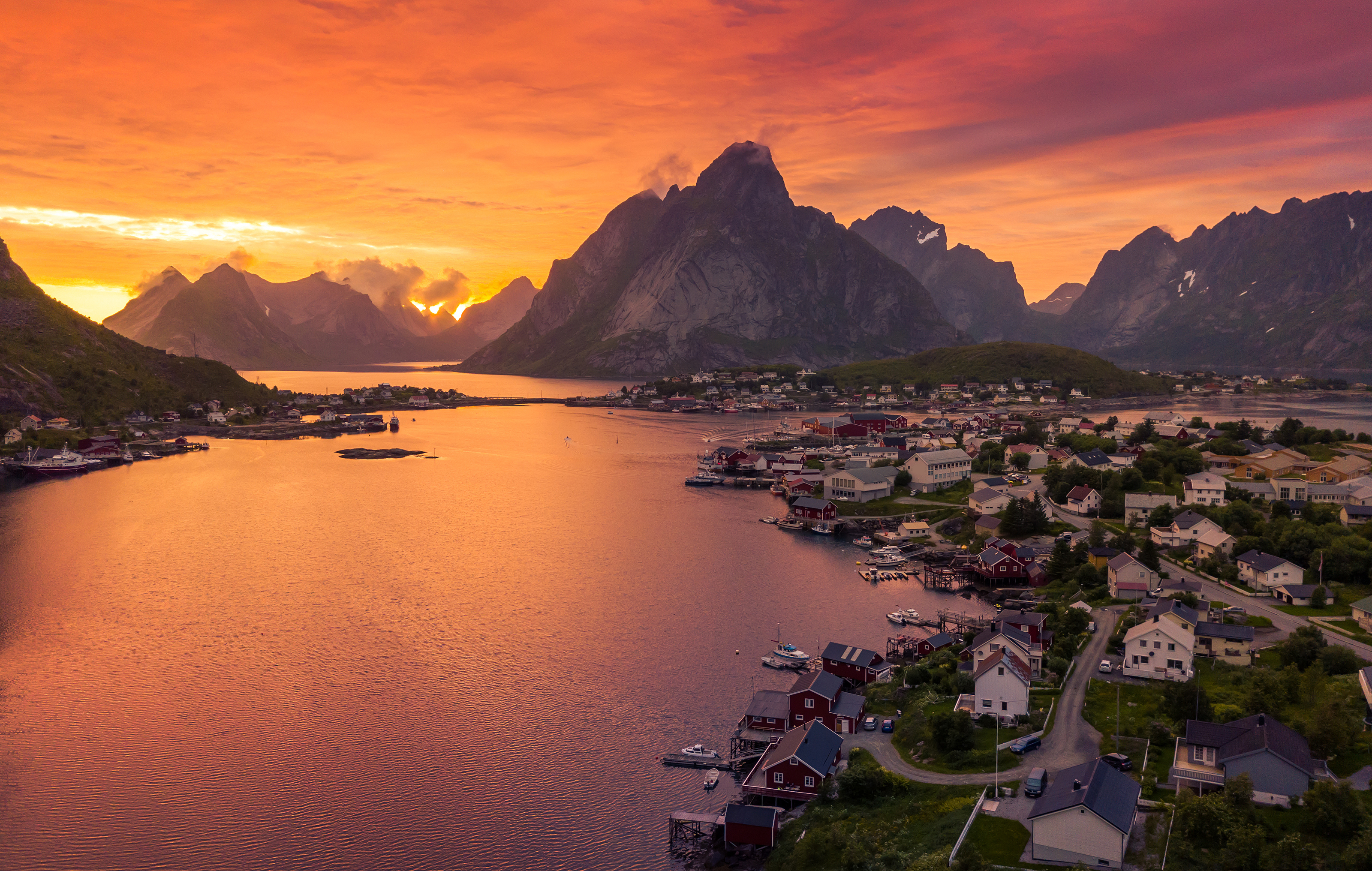 Spektakulær solnedgang over Reine fiskerlandsby i Lofoten Norge med dramatiske bjerge og farverig himmel