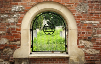 Den historiske jødiske Remuh-kirkegård fra 1535 i Kazimierz-kvarteret i Krakow, set gennem et gitter med Davidsstjernen