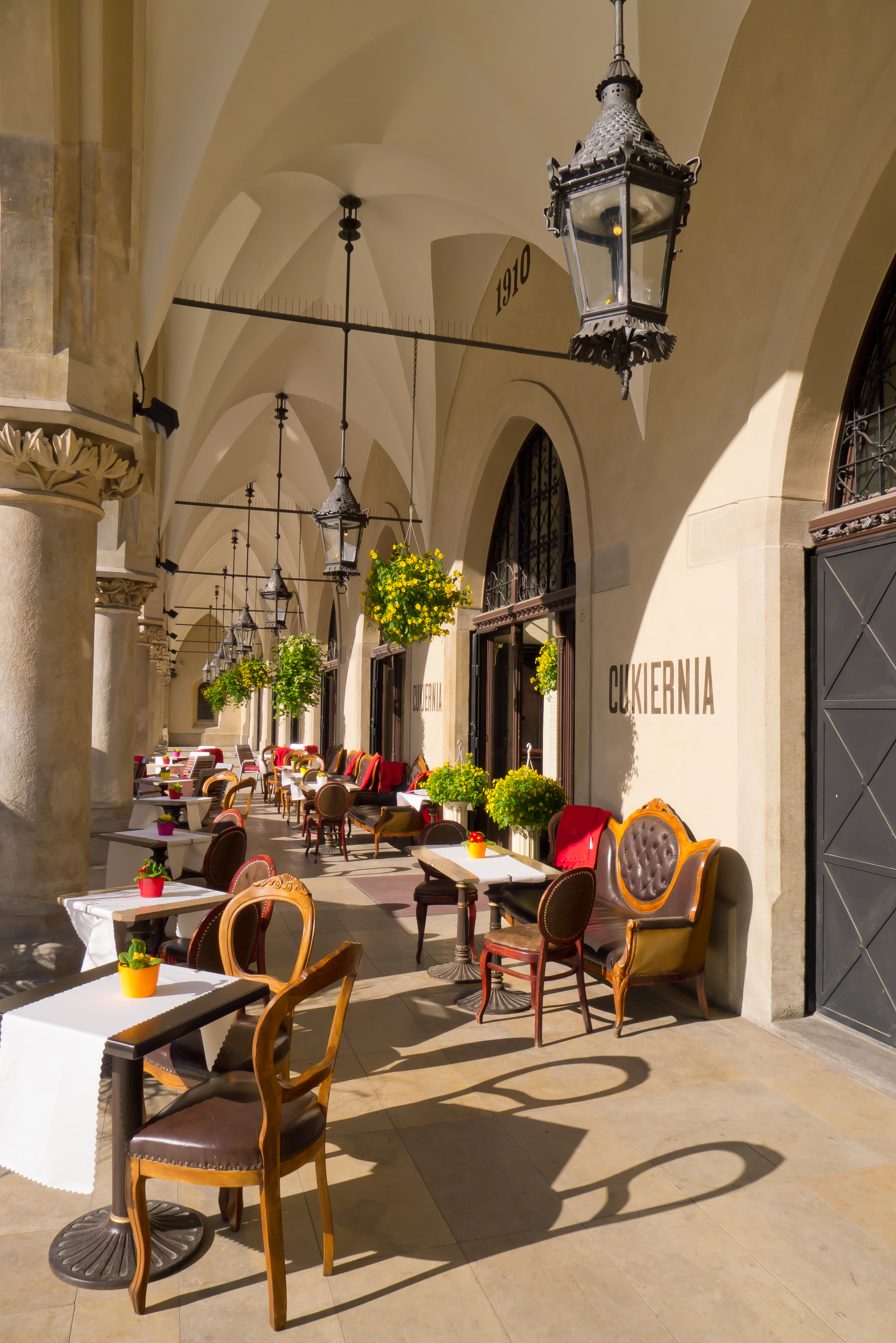 Elegant restaurantterrasse med historiske buer, ornamenterede lanterner og udendørs spiseborde på middelhavshotel