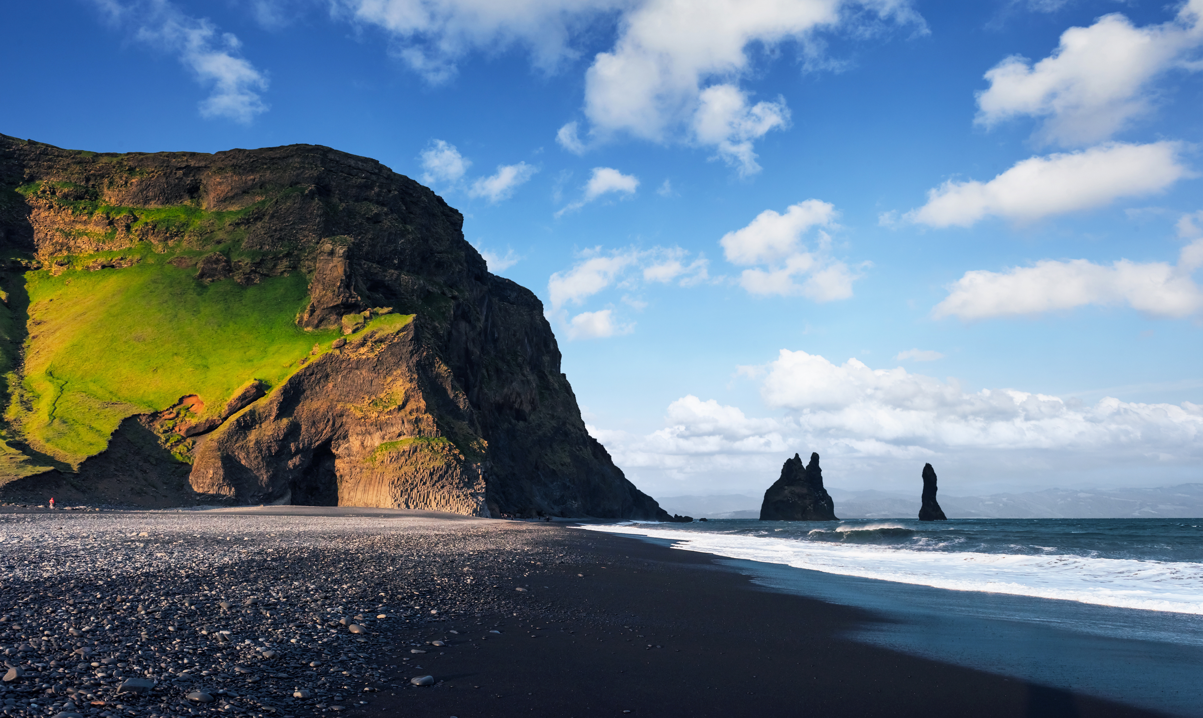 De berømte Reynisdrangar klippeformationer, der rejser sig fra havet ved den sorte Reynisfjara-strand nær Vik i det sydlige Island