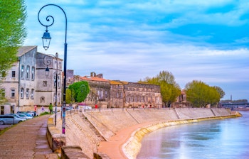Smuk solnedgang over Rhône-floden ved den historiske by Arles i Provence, Frankrig med romersk arkitektur