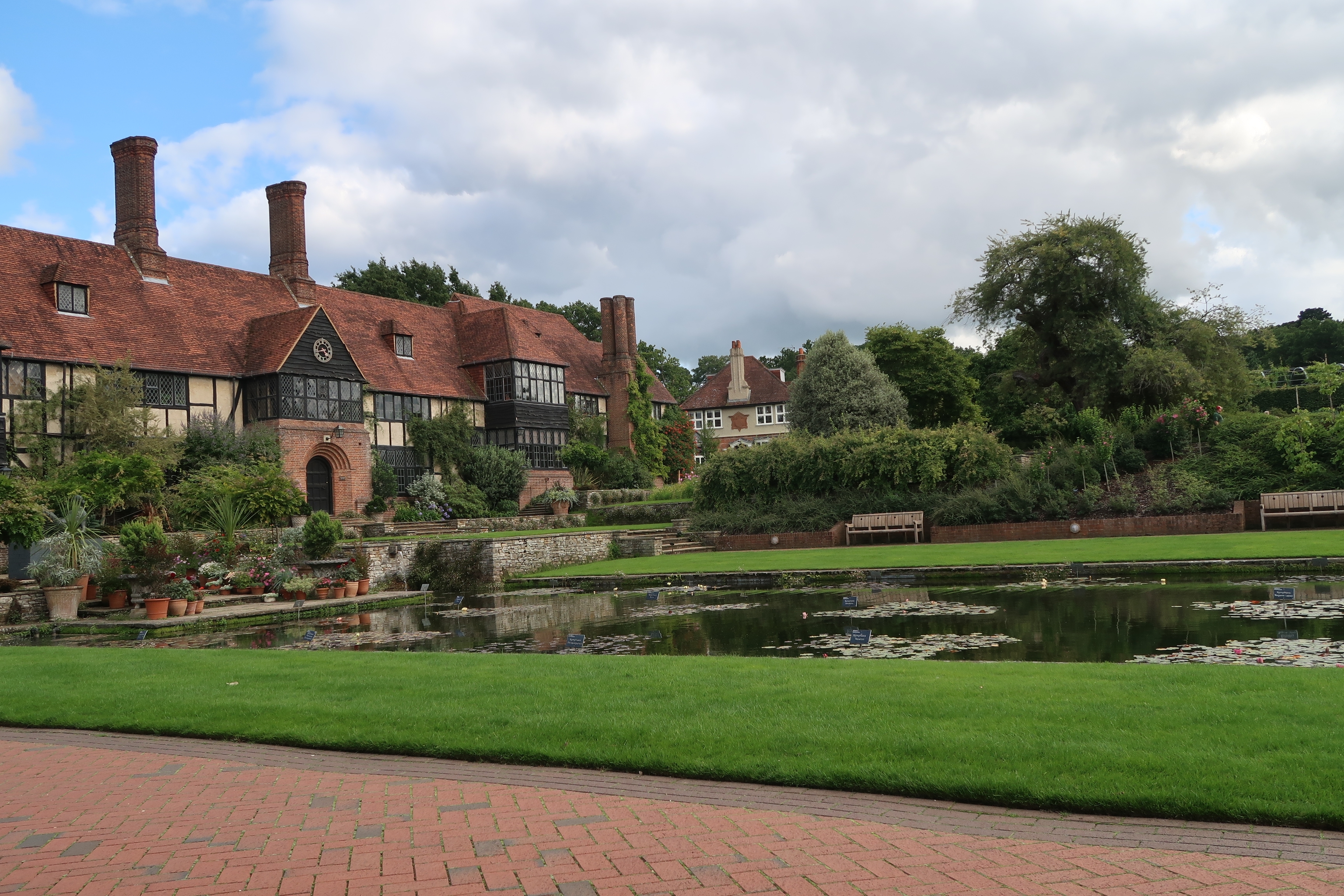 Idyllisk sommerlandskab i RHS Wisley Haven med farverige blomster og frodig natur under blå himmel i England