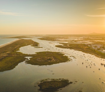 Flot solnedgang over Ria Formosa lagune med både og sandbanker i Algarve Portugal