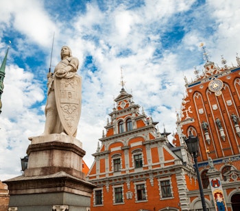 Rigas historiske centrum med House of the Blackheads, Roland-statuen og Skt. Peters kirketårn under blå himmel