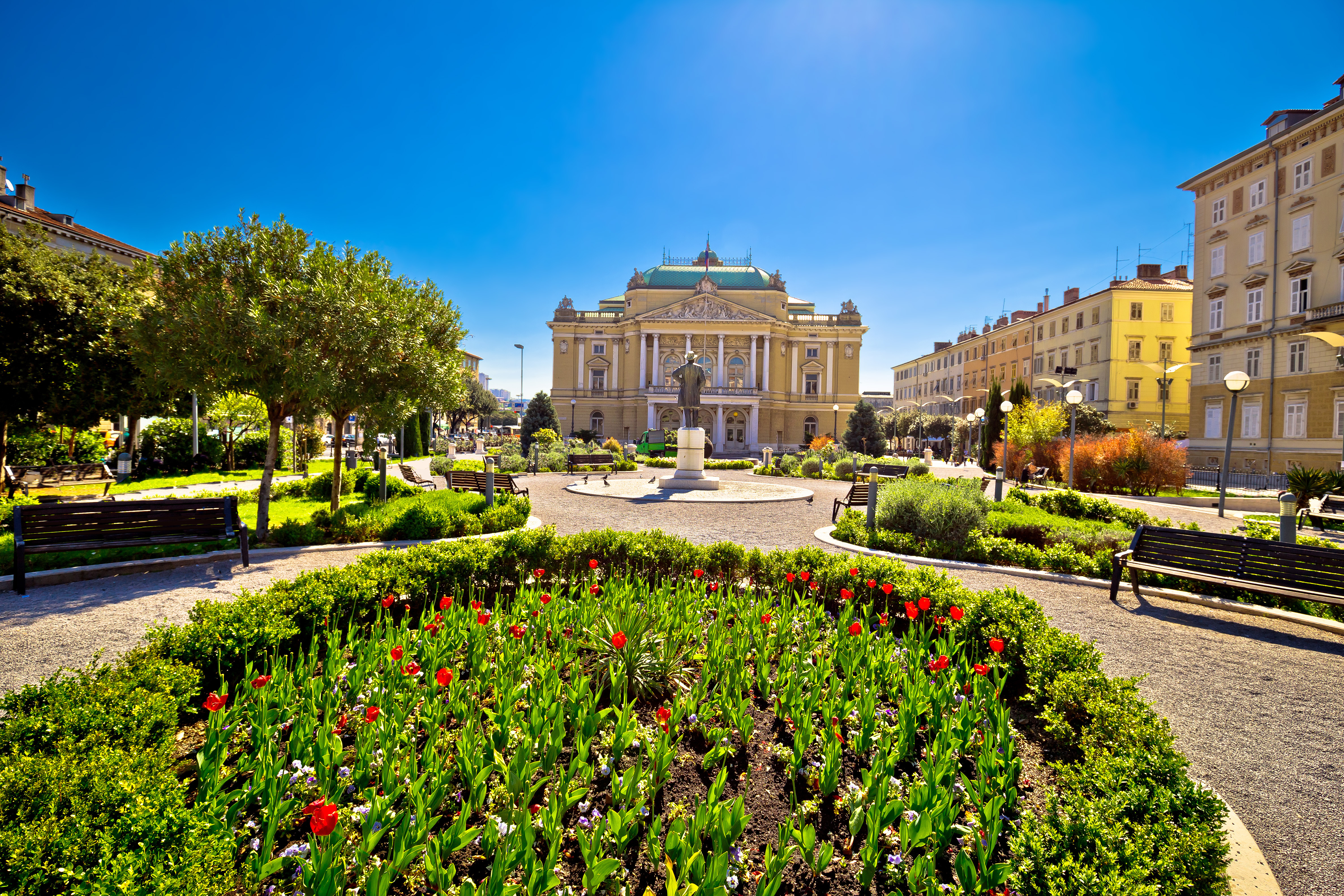Det kroatiske nationalteater i Rijeka med smukke haver og farverige blomster