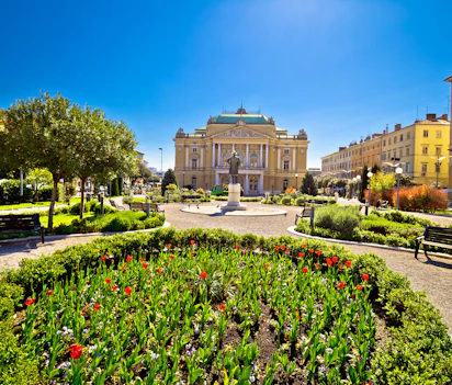 Det kroatiske nationalteater i Rijeka med smukke haver og farverige blomster