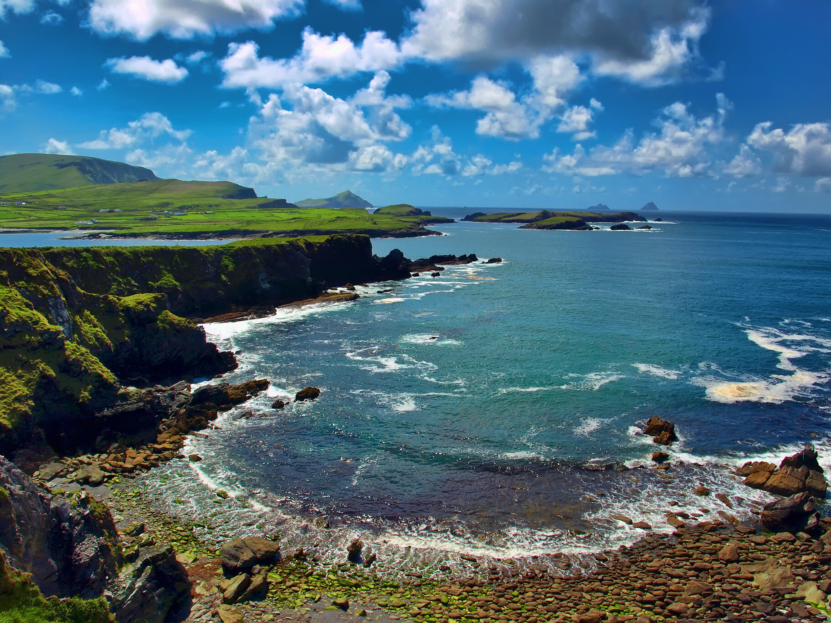 Storslået kystlandskab fra Ring of Kerry i Irland med turkisblåt hav, sandstrand og grønne bakker - den ikoniske udsigt over Atlanterhavet med Skellig Michael i det fjerne på Wild Atlantic Way