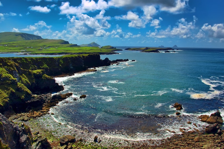 Storslået kystlandskab fra Ring of Kerry i Irland med turkisblåt hav, sandstrand og grønne bakker - den ikoniske udsigt over Atlanterhavet med Skellig Michael i det fjerne på Wild Atlantic Way