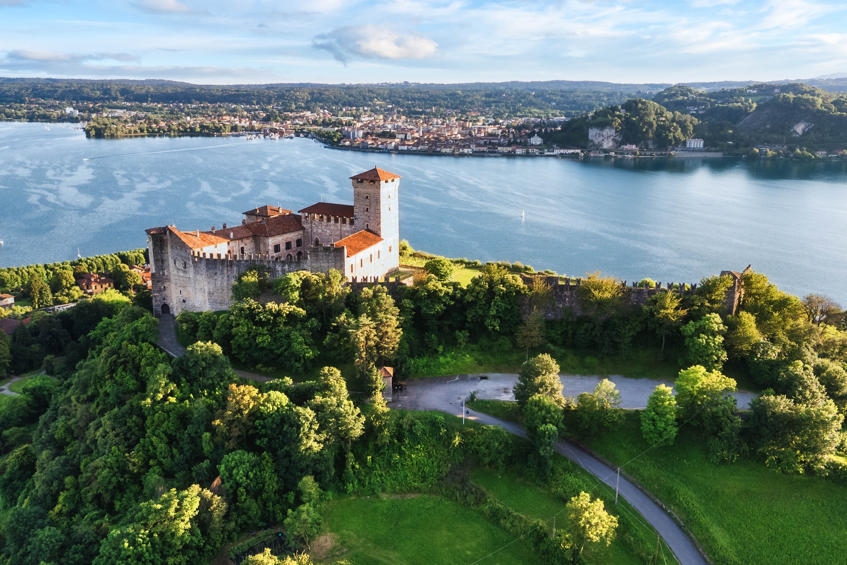 Luftfoto af den historiske Rocca Borromea fæstning med udsigt over Maggiore-søen og Arona by i baggrunden, Angera, Lombardiet, Italien