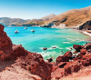 Den berømte røde strand ved Akrotiri på Santorini med karakteristiske røde vulkanske klipper og turkisblåt hav