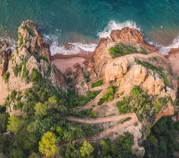 De dramatiske røde klipper ved Esterel kysten nær Theoule sur Mer på den franske riviera med azurblåt Middelhav