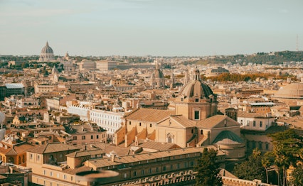 Panoramaudsigt over Rom med Santa Maria di Loreto kirken i forgrunden og Peterskirkens kuppel i baggrunden, Italien