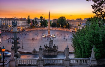 Smuk solnedgang over Piazza del Popolo i Rom med udsigt over den historiske arkitektur og byens ikoniske skyline i den evige stad