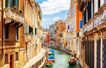 Idyllisk udsigt over Rio Marin-kanalen i Venedig med farverige historiske bygninger og traditionelle gondoler under blå himmel